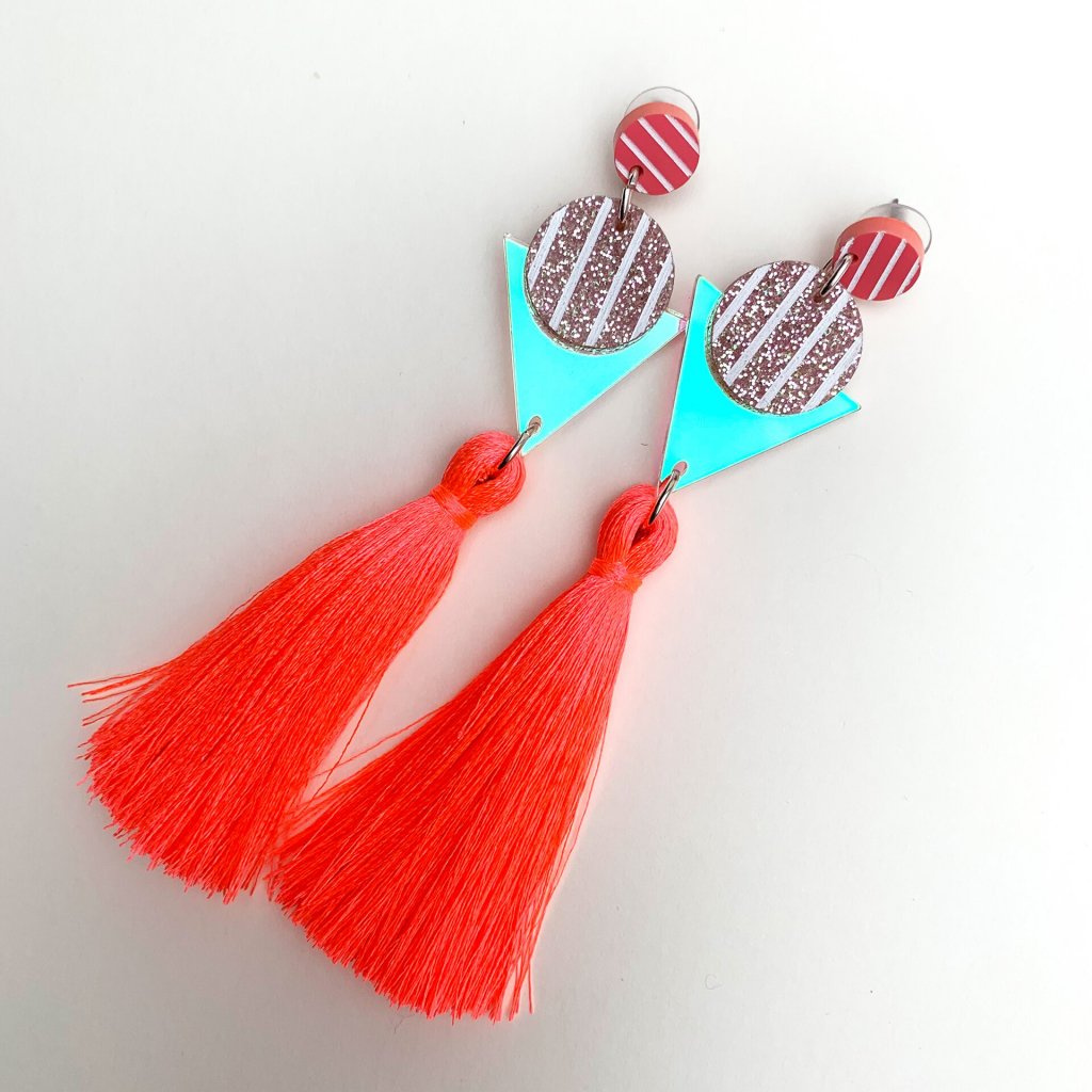 product shot of neon coral tassel earrings