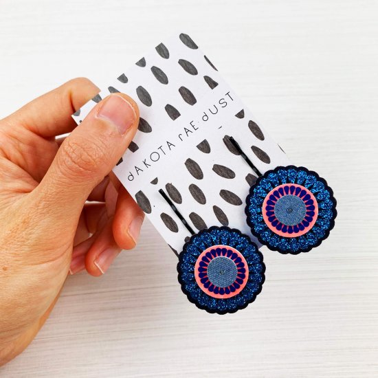 glittery ornate charm hair pins on a black and white pattermed backing card