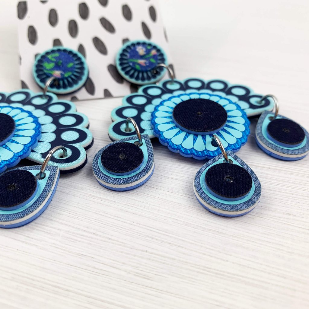 Statement earrings cut from blue fabric, seen from the side to show depth of material