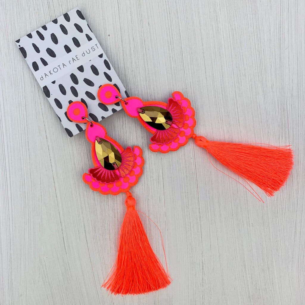 A pair of hot pink tassel earrings with gold gems