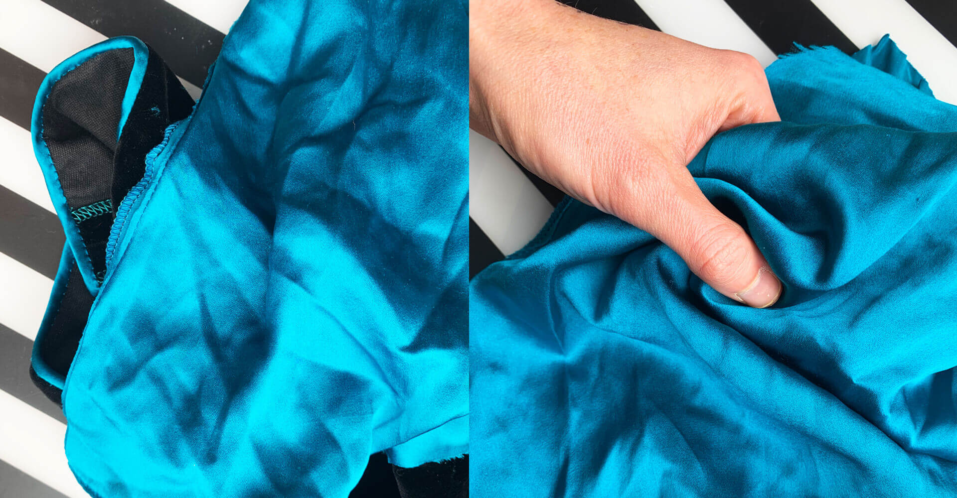 A close up of some teal coloured satin fabric, seen against a bold black and white striped background. A woman's hand is holding the fabric and some of the black velvet bodice of the original dress is visible