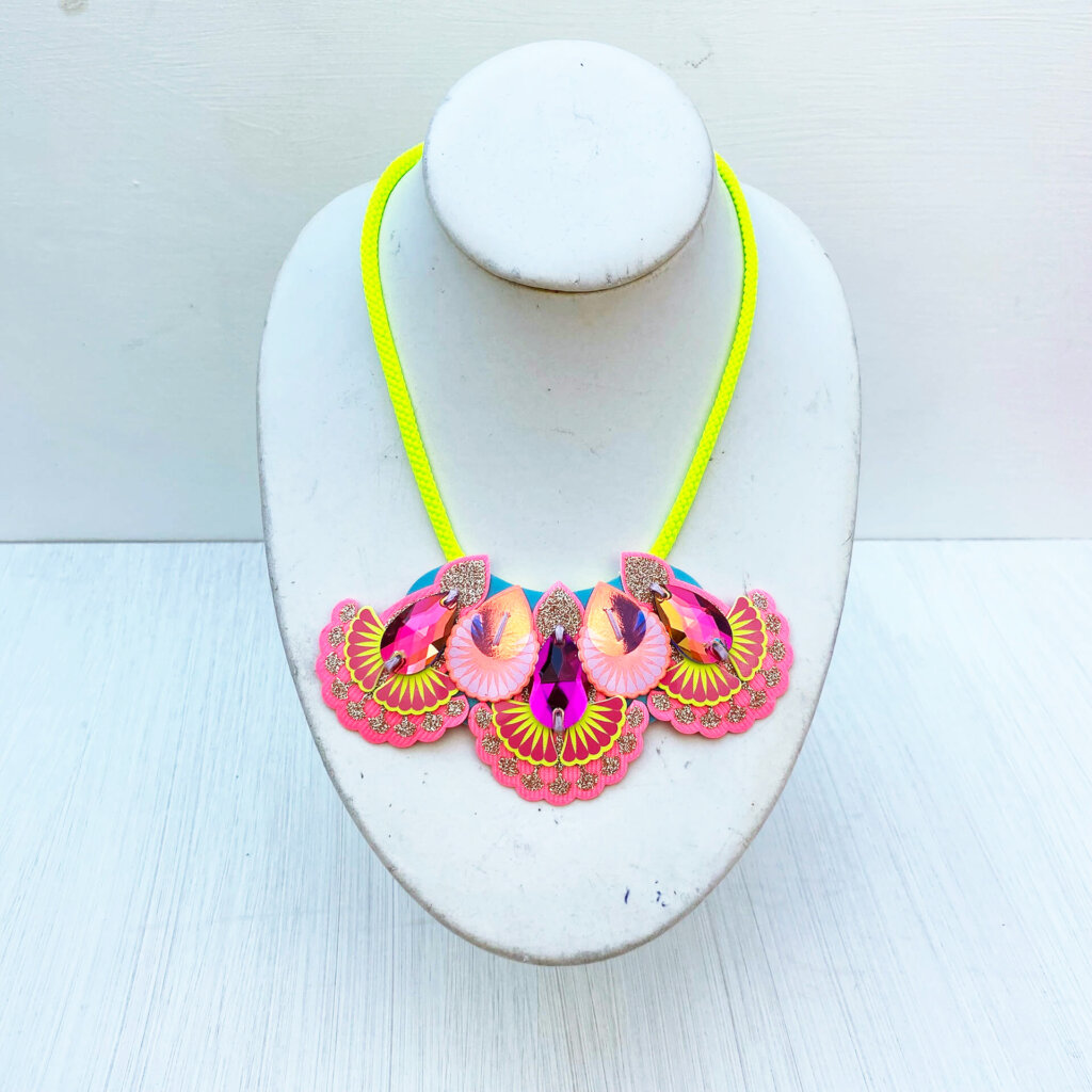 A coral, pink and fluoro yellow mini neon bib necklace modelled on a mannequin neck